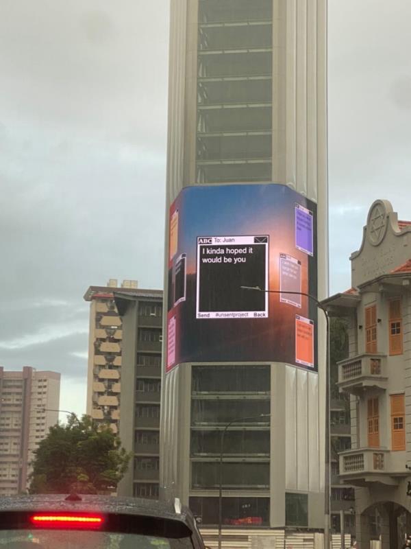 Unsent messages displayed on a billboard wrapped around a building